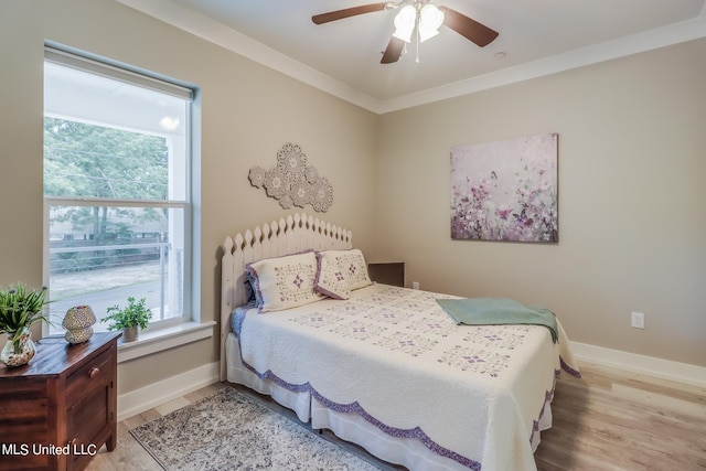 bedroom with light hardwood / wood-style floors, crown molding, and ceiling fan