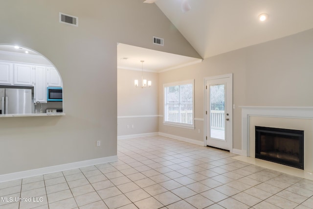 2616 Rue Palafox, Biloxi, MS 39531 - unfurnished living room with a fireplace with flush hearth, high vaulted ceiling, light tile patterned flooring, a chandelier, and baseboards