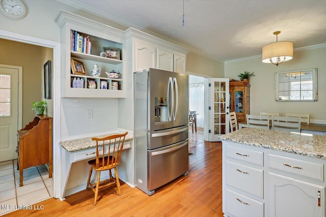 911 Tetbury Pl, Brandon, MS 39047 - kitchen with stainless steel fridge with ice dispenser, white cabinets, light wood finished floors, ornamental molding, and light stone counters