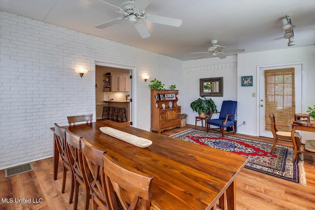 911 Tetbury Pl, Brandon, MS 39047 - dining space with a ceiling fan, wood finished floors, and brick wall