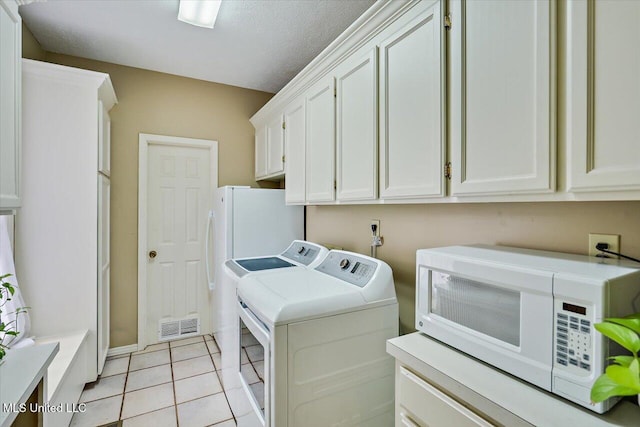 911 Tetbury Pl, Brandon, MS 39047 - laundry area featuring washer and dryer, cabinet space, light tile patterned flooring, a textured ceiling, and baseboards