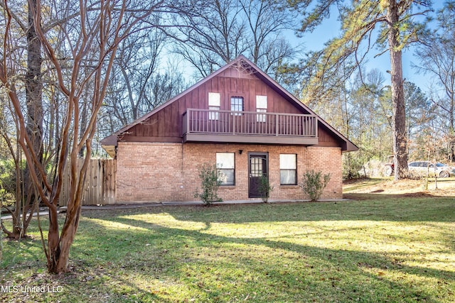 back of property featuring a balcony and a lawn