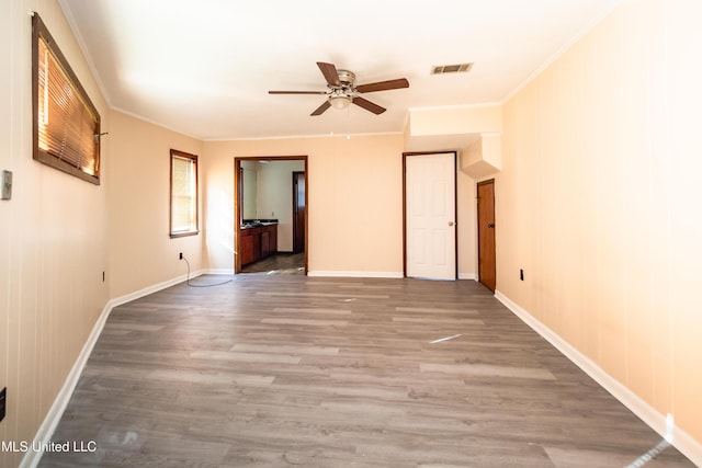 spare room featuring hardwood / wood-style flooring, crown molding, and ceiling fan