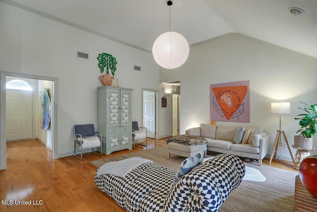 living room with high vaulted ceiling and light wood-type flooring