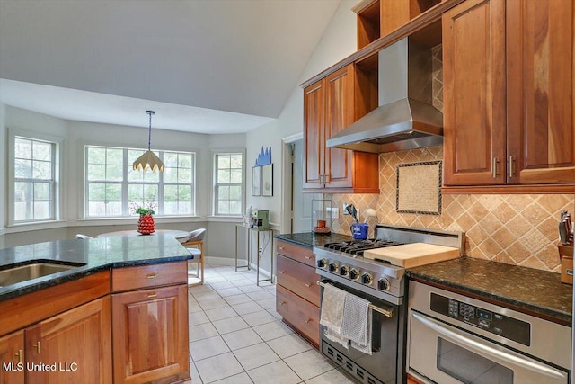 kitchen with light tile patterned flooring, backsplash, appliances with stainless steel finishes, lofted ceiling, and wall chimney exhaust hood