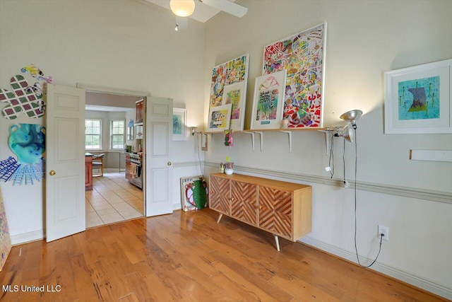 interior space featuring light wood-type flooring, stainless steel range, and ceiling fan