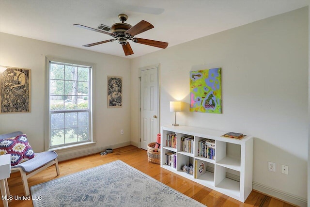 sitting room with ceiling fan and light hardwood / wood-style flooring