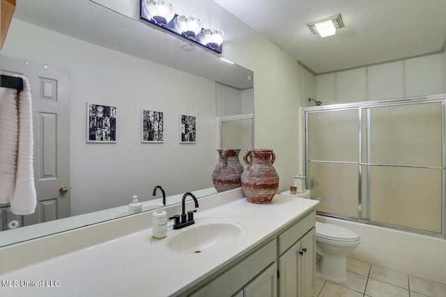 full bathroom featuring tile patterned flooring, shower / bath combination with glass door, toilet, and vanity