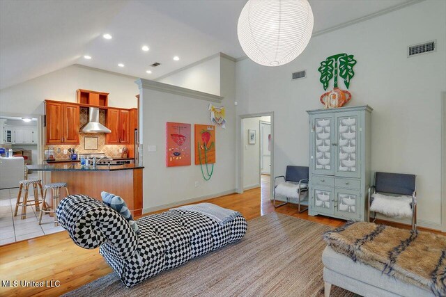 bedroom featuring high vaulted ceiling, sink, light hardwood / wood-style floors, and crown molding