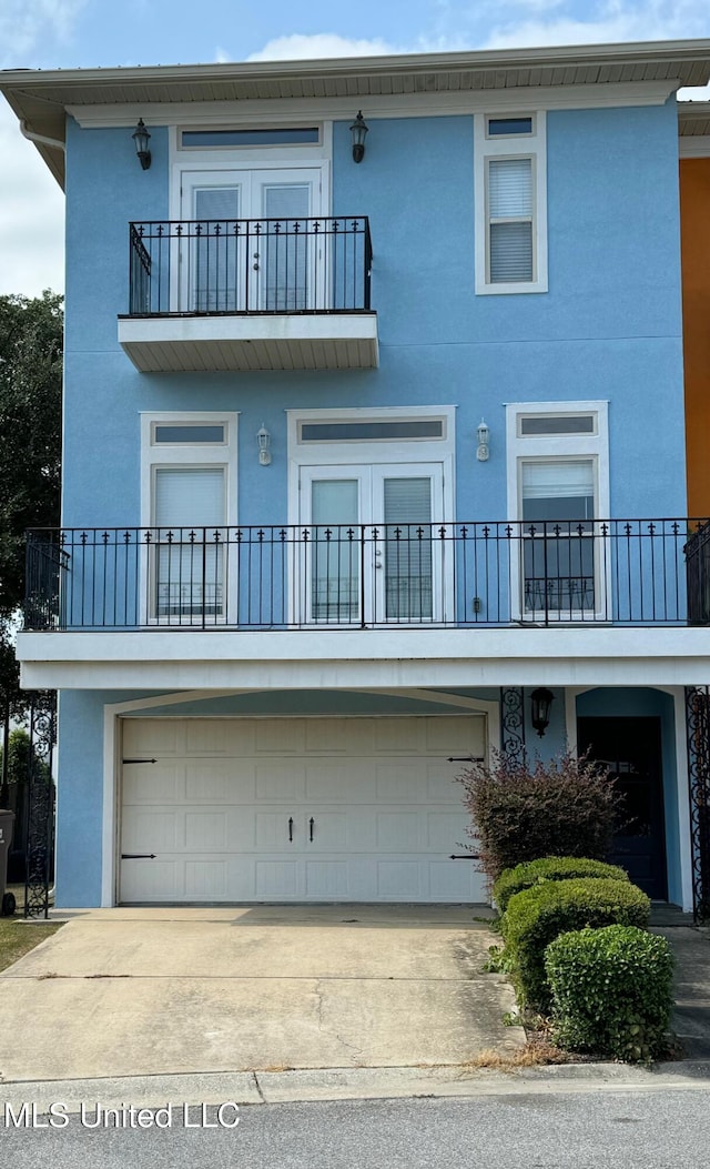 back of house featuring a balcony and a garage