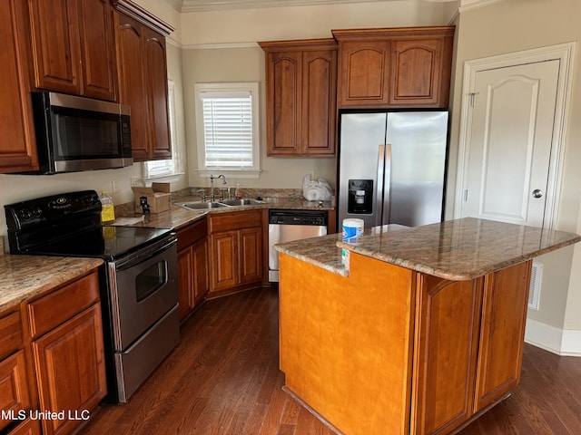 kitchen featuring dark hardwood / wood-style floors, stainless steel appliances, crown molding, sink, and a center island