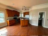 kitchen featuring a center island, stove, stainless steel refrigerator, an inviting chandelier, and dark hardwood / wood-style floors