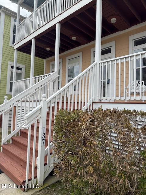 view of property exterior with stairway and a porch