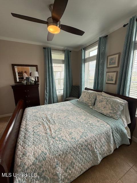 tiled bedroom featuring ornamental molding, ceiling fan, and baseboards