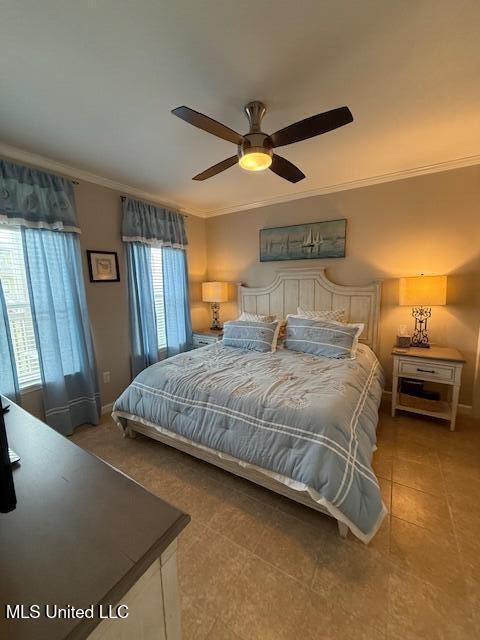 bedroom featuring baseboards, tile patterned flooring, a ceiling fan, and crown molding