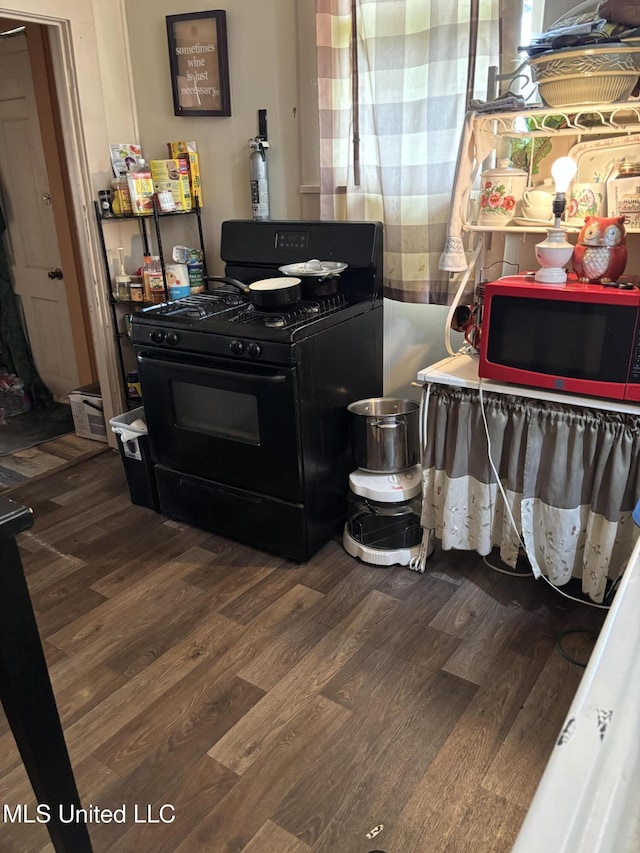 15 E Franklin St, Natchez, MS 39120 - detailed view of black range with gas stovetop and wood finished floors