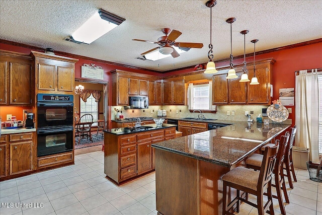 kitchen featuring a breakfast bar, black appliances, a wealth of natural light, and ornamental molding