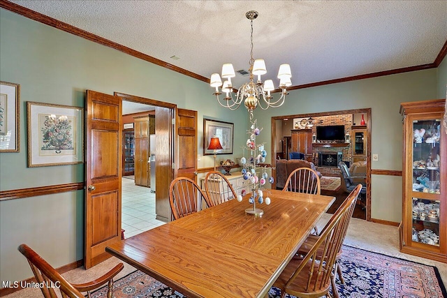 carpeted dining space featuring an inviting chandelier, a textured ceiling, a brick fireplace, and crown molding