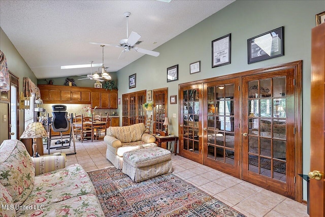 living room featuring a textured ceiling, light tile patterned floors, and ceiling fan