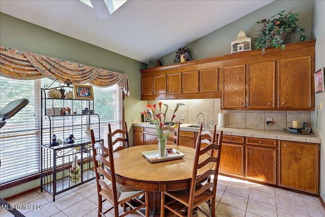 1600 Pine Hill Dr, Raymond, MS 39154 - dining room with vaulted ceiling, light tile patterned floors, a ceiling fan, and a textured ceiling