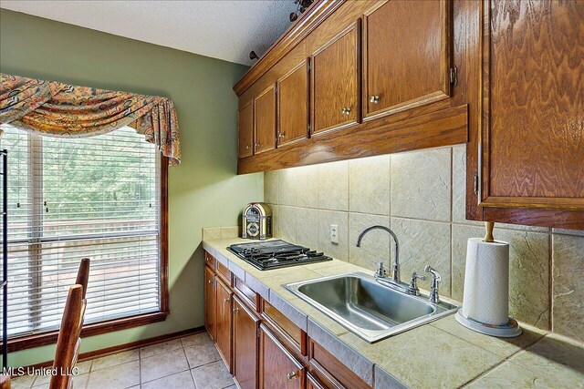 1600 Pine Hill Dr, Raymond, MS 39154 - kitchen with a sink, tasteful backsplash, plenty of natural light, and brown cabinets