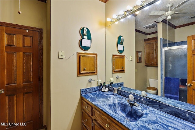 bathroom with a textured ceiling, toilet, ornamental molding, a shower with shower door, and vanity