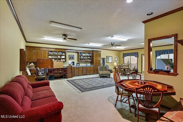 living room featuring ceiling fan, carpet flooring, a textured ceiling, and ornamental molding