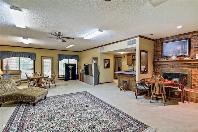 1600 Pine Hill Dr, Raymond, MS 39154 - living area featuring light colored carpet, crown molding, a ceiling fan, a brick fireplace, and a textured ceiling