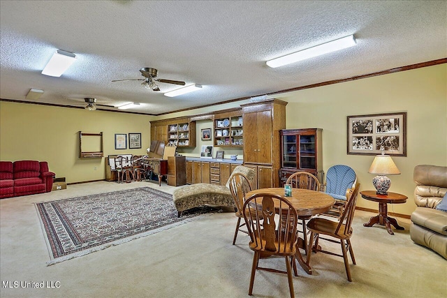 dining space with crown molding, ceiling fan, a textured ceiling, and carpet flooring