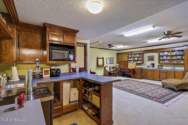 kitchen featuring light carpet, kitchen peninsula, black microwave, and a textured ceiling