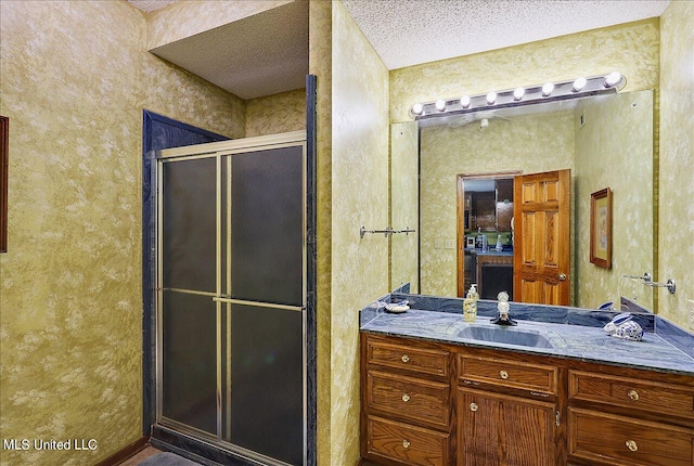 bathroom featuring vanity, a textured ceiling, and walk in shower