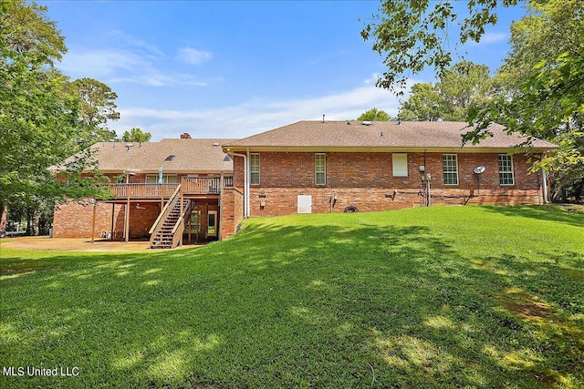 rear view of house with a deck and a lawn