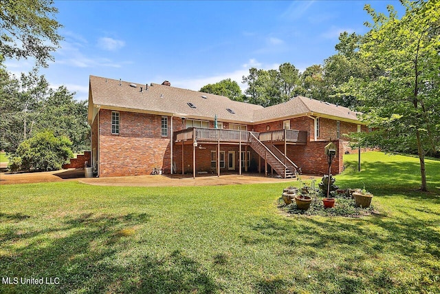 rear view of house featuring a wooden deck and a lawn