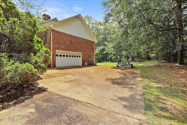 1600 Pine Hill Dr, Raymond, MS 39154 - view of home's exterior featuring concrete driveway, a chimney, a garage, and brick siding