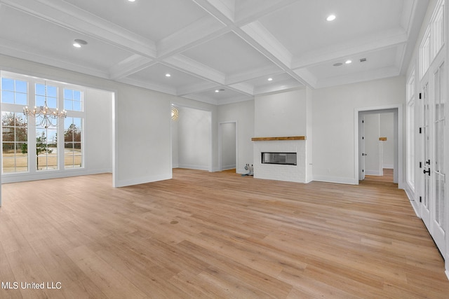 54 Windermere Blvd, Madison, MS 39110 - unfurnished living room with a chandelier, light wood-style flooring, beam ceiling, a glass covered fireplace, and baseboards