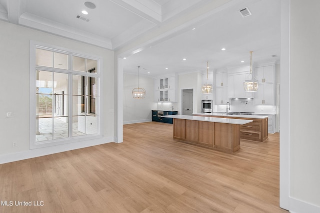 54 Windermere Blvd, Madison, MS 39110 - kitchen with light countertops, baseboards, light wood-style flooring, a large island with sink, and crown molding