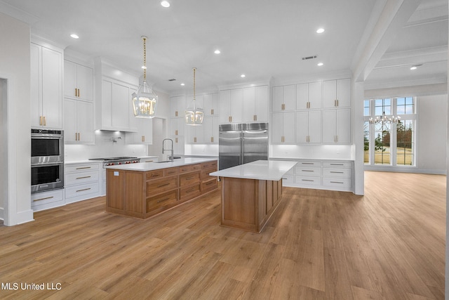 54 Windermere Blvd, Madison, MS 39110 - kitchen featuring stainless steel appliances, a chandelier, a large island, light wood-style flooring, and ornamental molding