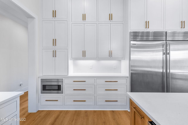 54 Windermere Blvd, Madison, MS 39110 - kitchen with stainless steel built in refrigerator, light wood finished floors, light countertops, and white cabinetry