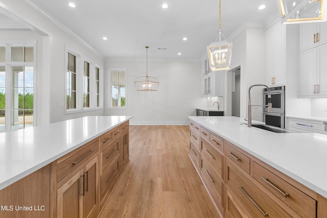 54 Windermere Blvd, Madison, MS 39110 - kitchen featuring light wood-type flooring, double oven, light countertops, white cabinets, and a chandelier