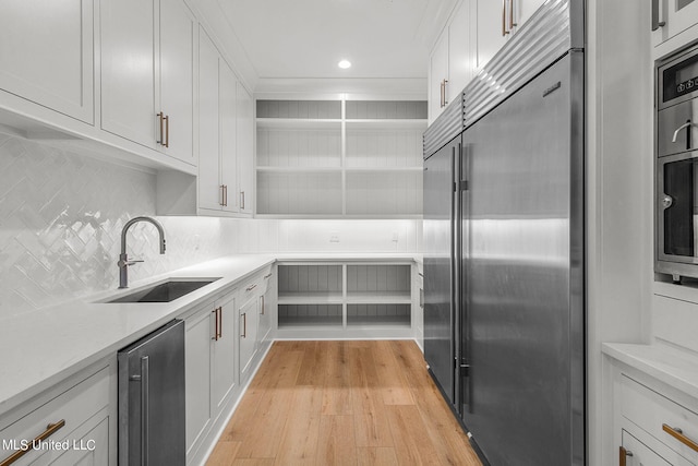 54 Windermere Blvd, Madison, MS 39110 - kitchen with built in fridge, a sink, open shelves, tasteful backsplash, and light wood-style floors