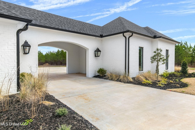 54 Windermere Blvd, Madison, MS 39110 - view of side of home featuring driveway, brick siding, a shingled roof, and a carport