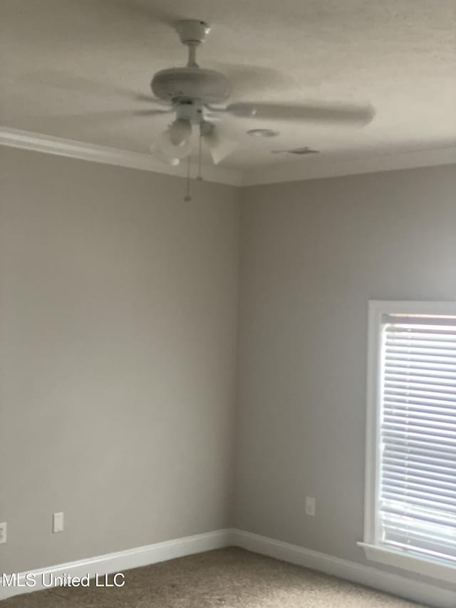 empty room featuring crown molding, carpet, and ceiling fan