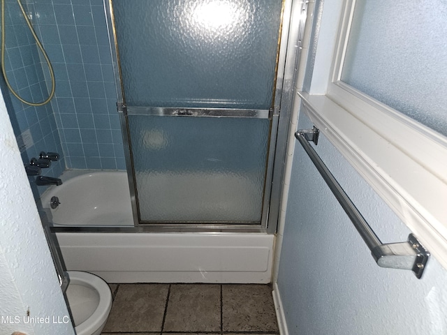 bathroom with tile patterned floors, enclosed tub / shower combo, and toilet