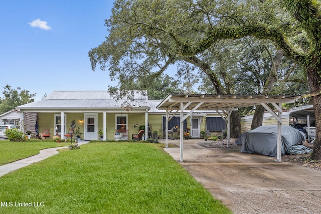 view of front of home featuring a carport, covered porch, and a front yard