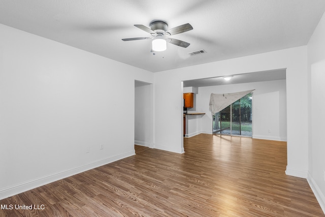 empty room with ceiling fan and wood-type flooring