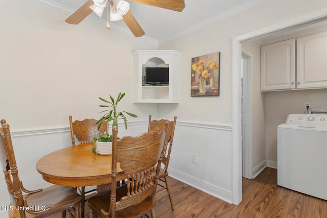 dining area featuring dark wood-type flooring, crown molding, washer / clothes dryer, and ceiling fan