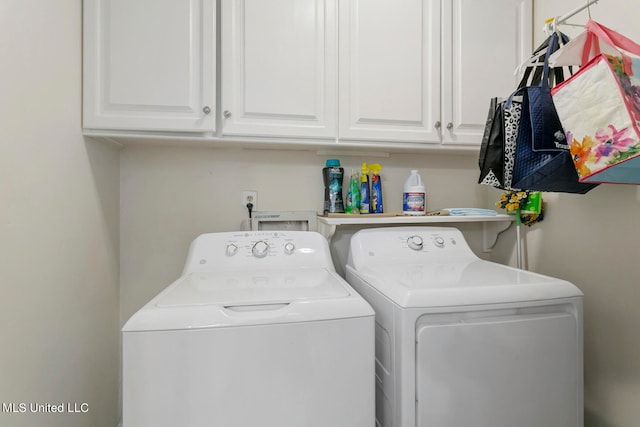 clothes washing area with washer and dryer and cabinets