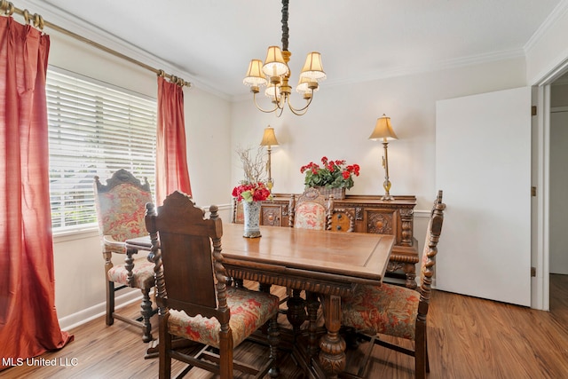 dining area featuring light hardwood / wood-style flooring, a chandelier, and crown molding