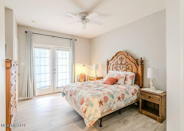 bedroom with access to outside, french doors, ceiling fan, a textured ceiling, and light hardwood / wood-style floors