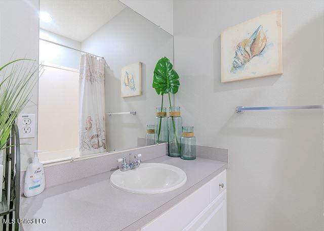 bathroom with curtained shower and vanity